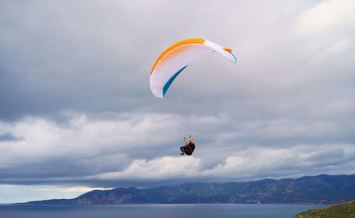 Person paragliding against sky