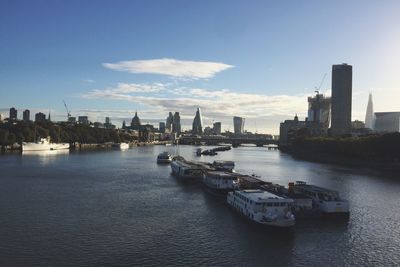 Boats in river with city in background