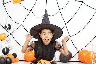Portrait of smiling boy with arms raised during halloween