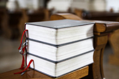 Close-up of bibles on bench in church