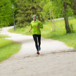 Full length of woman running on footpath