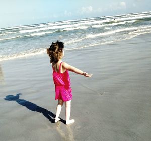 Rear view of woman walking on beach