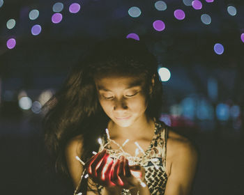 Young woman in city at night