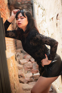 Young woman lying on wall