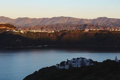 Scenic view of lake by mountains against sky