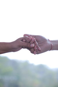 Cropped hand of woman gesturing against white background