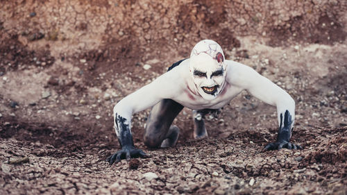 Portrait of evil man standing on field