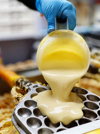 Cropped hand of woman holding waffle ball batter 