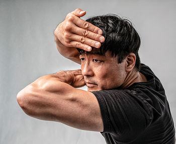 Portrait of man making face against gray background