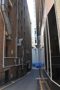 Empty road amidst buildings in city