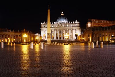Illuminated cathedral and column at st peter square