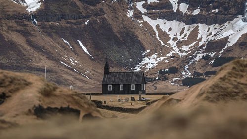 Full frame view of the black church of budir with mountain valley with snow in the background