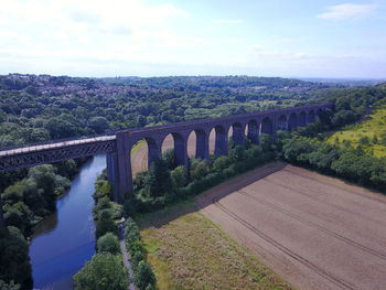 Arch bridge over river against sky