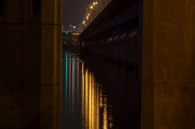 Reflection of light by bridge over river at night