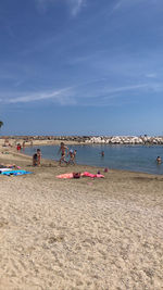 People on beach against blue sky