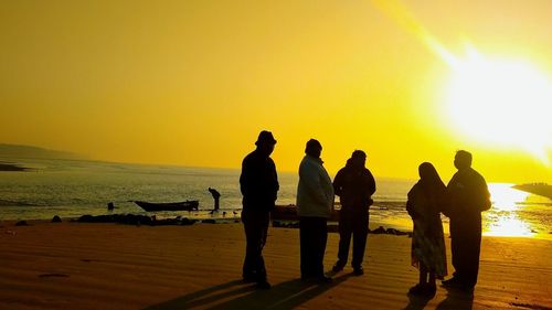 Silhouette people on beach during sunset