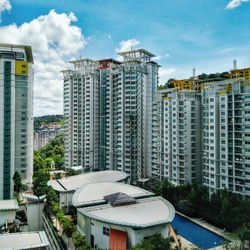 Buildings in city against cloudy sky