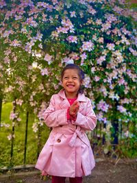 Portrait of young woman standing against trees