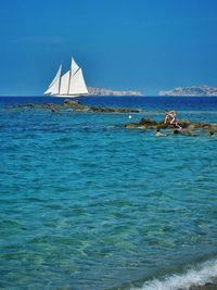 Boats in sea against clear sky