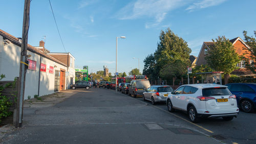 Cars on street amidst buildings in city against sky