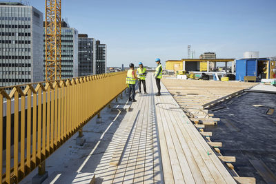 People at construction site against buildings in city