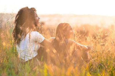 Smiling sisters sitting amidst plants