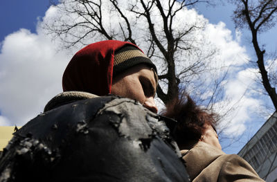 Low angle portrait of man against sky during winter