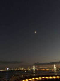 Illuminated bridge against sky at night