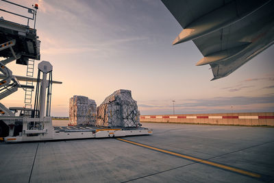 Preparation freight airplane before flight. loading of cargo containers to plane at airport.