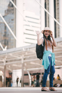 Tourist with luggage standing on steps in city