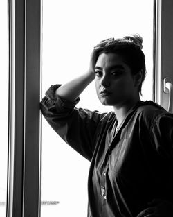 Young man looking through window