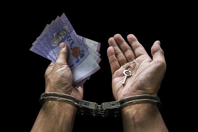 Close-up of human hand against black background