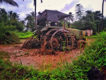 Abandoned truck on field against sky