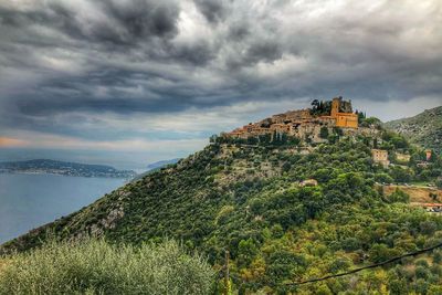 View of castle on mountain against cloudy sky
