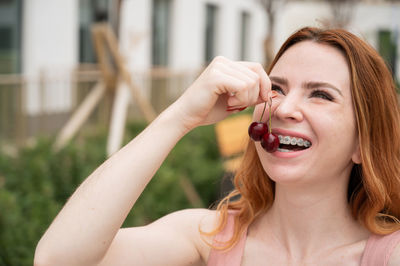 Young woman eating cherry
