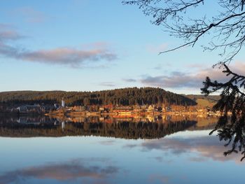 Scenic view of lake by buildings against sky