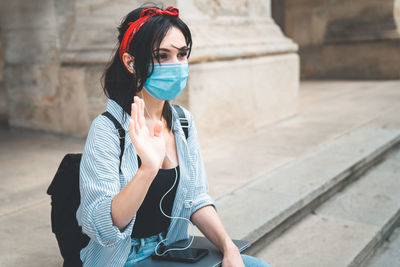 Young woman standing against buildings in city