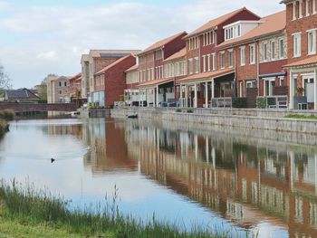 Reflection of buildings in lake against sky