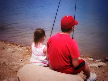 Rear view of girl sitting on beach
