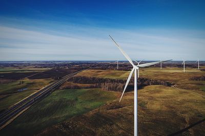 Wind turbines in farm against sky