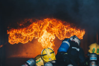 Rear view of firefighters extinguishing fire 