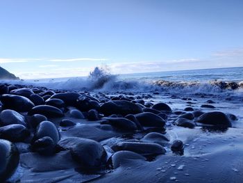 Rocks on beach against sky