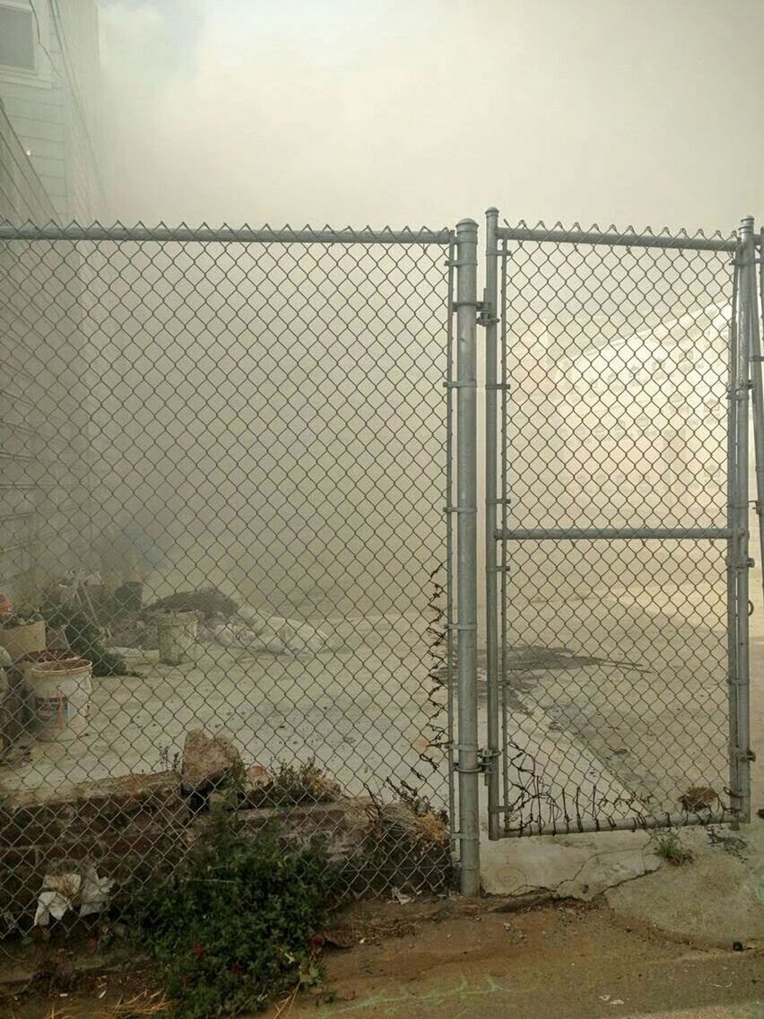 VIEW OF ROAD THROUGH CHAINLINK FENCE