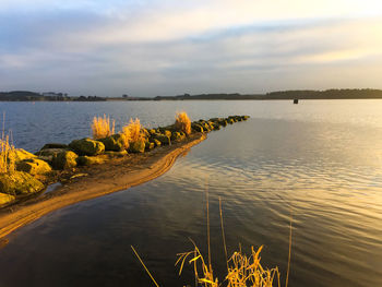 Scenic view of lake against cloudy sky