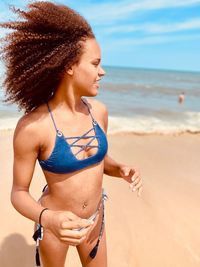 Young woman in bikini standing on beach