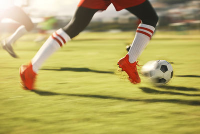 Low section of man playing soccer on field