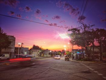 Cars on street in city at sunset