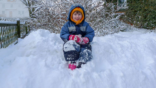 Portrait of boy sitting on snow 