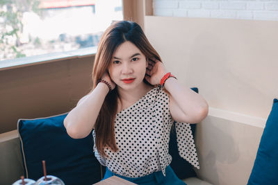 Portrait of young woman sitting at home