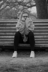 Woman sitting on bench in park